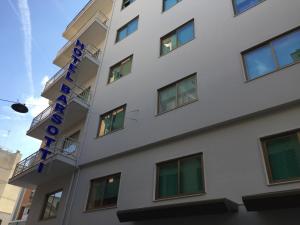 布林迪西巴尔索缇酒店的白色的建筑,上面有蓝色的标志