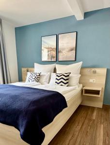 黑尔戈兰岛豪恩菲尔斯公寓的一间卧室配有一张带蓝色墙壁的大床