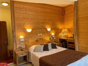 索略勃艮第酒店的卧室配有木墙内的一张床