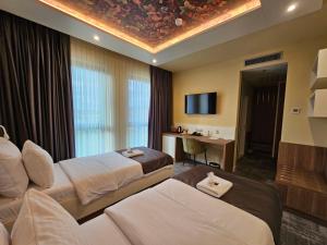 GračanicaHotel ETNA的一间酒店客房,设有两张床和电视