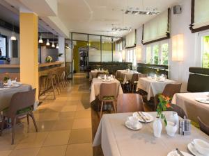 雷根斯堡ACHAT Hotel Regensburg Herzog am Dom的餐厅配有桌椅和白色的桌布
