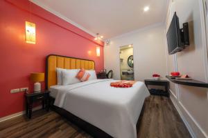 河内Omina Hanoi Hotel & Travel的卧室配有一张白色大床和红色墙壁