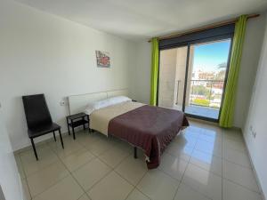 贝尼卡洛Apartamentos Playa de Benicarló 3000的卧室配有床、椅子和窗户。