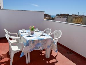 贝尼卡洛Apartamentos Playa de Benicarló 3000的一张桌子、白色的椅子和一张鲜花桌子