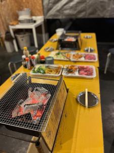 海津市Makino Kogen 123 Building / Vacation STAY 79154的黄色桌子,上面有食物和烤架