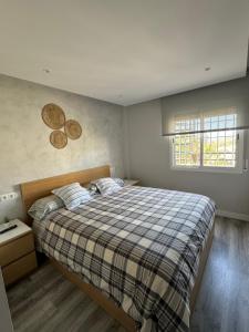马拉加Ático的一间卧室配有一张大床和一张铺着条纹毯子