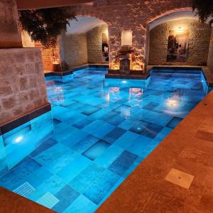 于尔居普卡帕多西亚弗雷斯科窟套房酒店的一座有蓝色灯光的房子里的游泳池