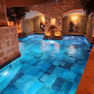 于尔居普卡帕多西亚弗雷斯科窟套房酒店的蓝色建筑中的室内游泳池
