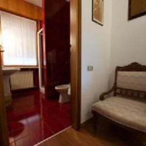特伦托Marzola的一间卧室设有一张床、一个窗口和一个卫生间