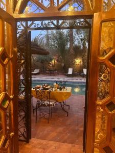 扎古拉Riad le petit jardin的一间带桌子和游泳池的用餐室