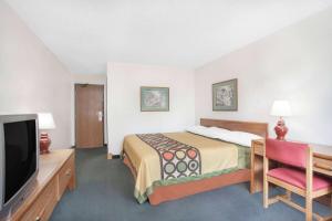 昆斯伯里格伦斯福尔斯速8酒店的配有一张床和一台平面电视的酒店客房