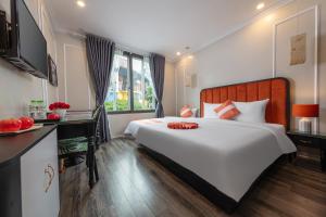 河内Omina Hanoi Hotel & Travel的卧室配有一张白色大床和一张书桌