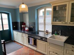 吕本瑙Suite im Limonadenhaus - adults only的厨房配有白色橱柜和水槽