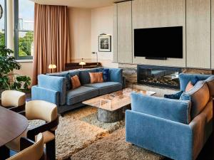 布鲁塞尔布鲁塞尔欧洲索菲特酒店的客厅配有蓝色的家具和壁炉