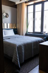 希奥利艾Four Sisters Luxury Rooms in Siauliai的一间卧室设有一张床和大窗户