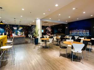 约恩维利ibis Joinville的一间带桌椅的餐厅和一间酒吧