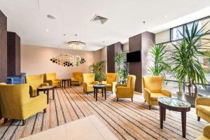克卢日-纳波卡汉普顿克卢日纳波卡希尔顿酒店的一间设有黄色椅子和桌子的等候室