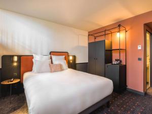 波尔多Mercure Bordeaux Centre Gare Atlantic的酒店客房配有一张带枕头的大型白色床。