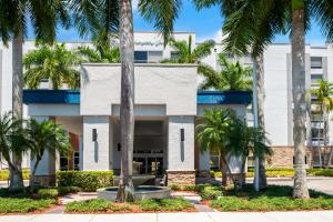韦斯顿Hampton Inn Weston Fort Lauderdale的一座白色的建筑,前面有棕榈树