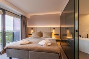 尤尔马拉优马拉温泉酒店的一间卧室配有一张大床和两条毛巾