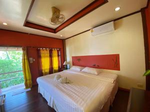 库德岛金纳瑞考库德度假旅馆的卧室配有白色床、红色床头板和窗户