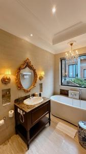 日惹Dandaman villa的带浴缸、水槽和镜子的浴室