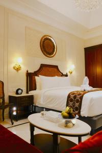 日惹Dandaman villa的酒店客房,配有一张床和一张桌子,还有一碗水果