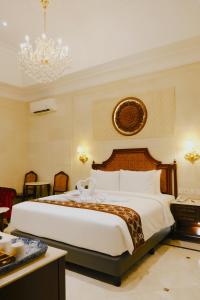 日惹Dandaman villa的一间卧室配有一张大床和一个吊灯。