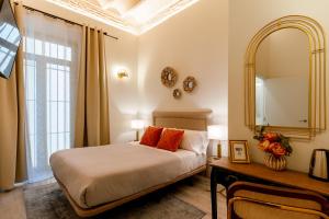 塞维利亚Arco de la Seda - Hotel Boutique的一间卧室配有一张床、镜子和一张桌子