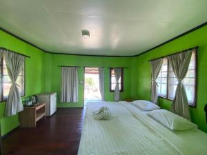 库德岛金纳瑞考库德度假旅馆的绿色卧室配有一张带白色枕头的大床