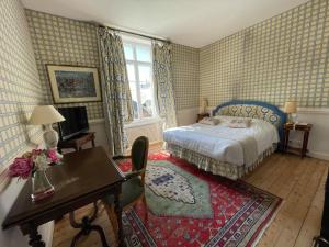 潘波勒K之罗伊斯酒店的一间卧室配有一张床、一张桌子和一张椅子