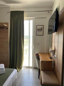佩雷亚佩雷亚酒店的配有一张床、一张书桌和一扇窗户的酒店客房