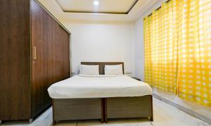 新德里FabExpress The Maharaja Grand的一间卧室设有一张床和一个大窗户
