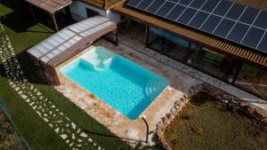 奥萨德蒙铁尔Casas Rurales Laguna La Tinaja的享有游泳池的顶部景色,毗邻带太阳能电池板的房子