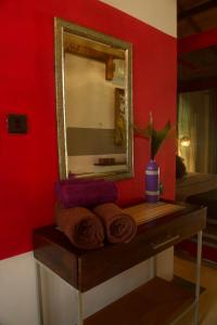 本托塔Red Coconut Villa的一张镜子,坐在一张带毛巾的木桌上