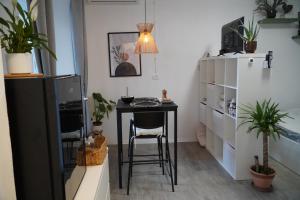 KomenComfortable Apartment & Studio in Village Centre的植物间的小桌子和椅子