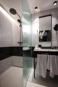 萨尔茨堡Gentle Hide Designhotel的带淋浴、盥洗盆和镜子的浴室