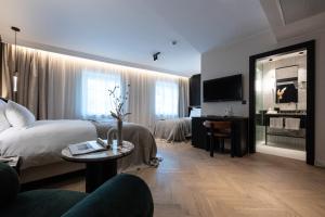 萨尔茨堡Gentle Hide Designhotel的大型酒店客房设有一张床铺和一张桌子。