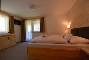 博希尼PRIVILLAGE Stare - B&B的一间卧室配有一张大白色的床和两颗粉红色玫瑰