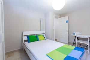 波尔图Relógio Guest House的客房内的白色床和色彩缤纷的枕头