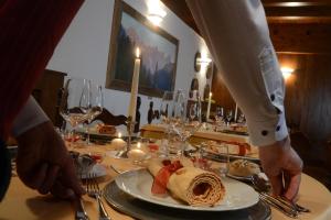圣马蒂诺-迪卡斯特罗扎Hotel Margherita的站在餐桌上,有盘子的食物的人
