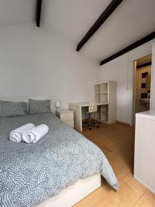 波尔图Relógio Guest House的一间卧室配有一张带白色床单的床和一张书桌。