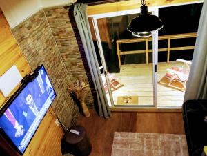 皮里亚波利斯Hermosa cabaña con excelente vista panorámica的享有客厅的顶部景色,设有电视和门廊