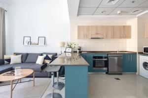迪拜Frank Porter - BayCentral的厨房以及带蓝色沙发的客厅。