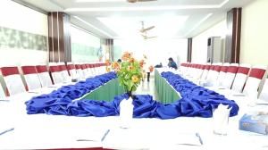 木尔坦Five Mounts Hotel And Restaurant的一张长桌,上面有蓝色桌布和鲜花