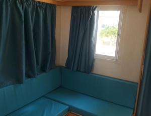 科马鲁加Camping Sant Salvador的窗户客房内的蓝色沙发