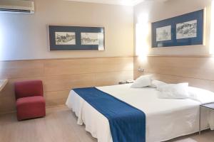 阿尔内多维尔雷酒店的卧室配有白色的床和红色椅子