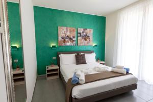 奥利维托拉里奥Bellagio Village- 4 Apartments by the lake - Seasonal Warm Pool and Sauna的一间卧室设有一张大床和绿色的墙壁