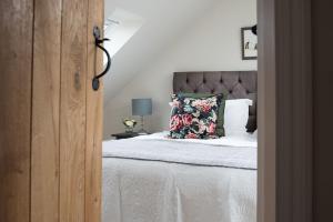 特维德上游的贝里克Mill Cottage, Brockmill Farm的一间卧室配有一张带枕头的床