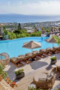 赫索尼索斯克里特布鲁精品酒店的一个带躺椅和遮阳伞的游泳池